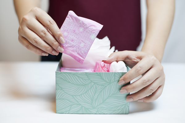 n pickinCloseup photo of young womag sanitary pad out of green box
