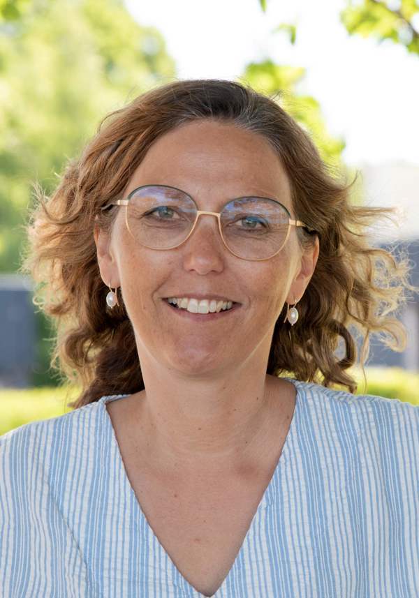 Portrait of Astrid Margrethe Hilde, looking at the camera smiling against an outdoors background.
