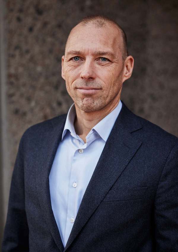 Portrait of Christian Must, looking at the camera with a neutral expression against a plain background.